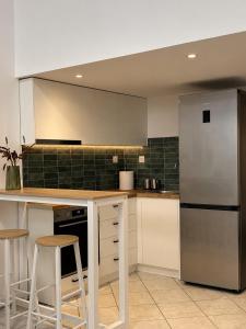 a kitchen with a refrigerator and a counter with stools at Tailor Urban Loft Thiva in Thiva +3 photos