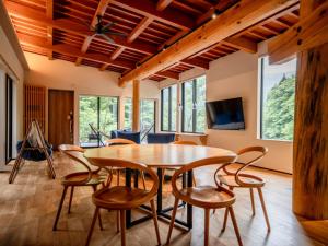 a dining room with a wooden table and chairs at 水杜のすみか大野屋 in Fukui