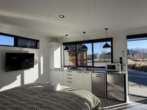 a white kitchen with a sink and a microwave at Simply Stunning Stars B in Lake Tekapo