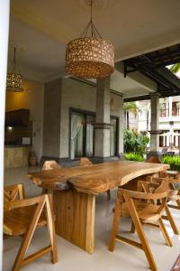 a large wooden table and chairs in a room at Umanara Ubud in Ubud