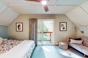 a bedroom with a bed and a couch and a window at Wooded-View Decks: Family Cabin Retreat in Deming in Warnick