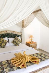 a bed with a pile of towels on it at Umanara Ubud in Ubud
