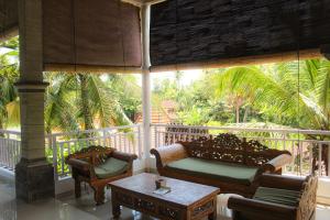 a porch with two couches and a coffee table at Umanara Ubud in Ubud