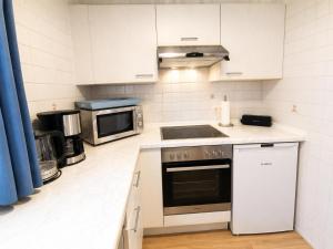 a kitchen with a stove and a microwave at Kleine Meereskrabbe in Werdum