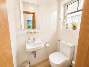 a white bathroom with a toilet and a sink at Kleine Meereskrabbe in Werdum +44 photos