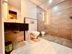 a bathroom with a toilet and a shower at The Raarees Mist Resort, Munnar - Nested in Nature's Lap in Munnar +42 photos