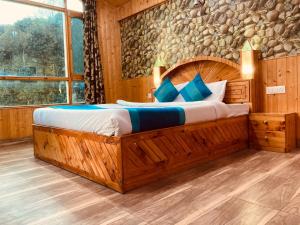 a bedroom with a large bed with a stone wall at The Raarees Mist Resort, Munnar - Nested in Nature's Lap in Munnar