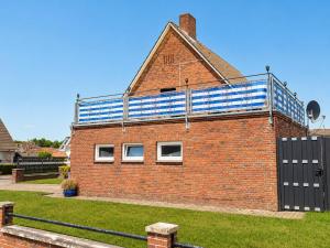 a brick building with a blue and white roof at Küstenlounge Dornumersiel in Dornum