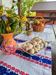 a table with a plate of food and a basket of fruit at Pensiunea Simona in Perişor