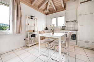 a white kitchen with a white table and chairs at COZY 3 !Gratis Parken, Free Parking! in Weinfelden