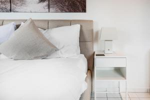 a bedroom with a bed with white pillows and a side table at COZY 3 !Gratis Parken, Free Parking! in Weinfelden