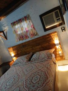 a bedroom with a bed with a wooden headboard and lights at Toucherit Standar in La Mira