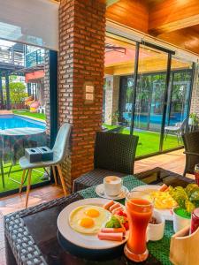 a table with two plates of eggs and food on it at Thongtara House Boutique Srinakarin in Bangkok