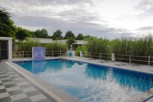 a swimming pool with blue water in a yard at Jawai Empire Resort by Premier Hotels - Luxury Tent & Cottage Stay - Leopard Safari Near Jawai Dam in Pāli