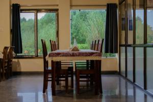 a dining room with a table and chairs and windows at Jawai Empire Resort by Premier Hotels - Luxury Tent & Cottage Stay - Leopard Safari Near Jawai Dam in Pāli