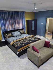 a bedroom with a large bed and a couch at EdJames Lodge in Ashaiman