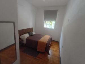 a bedroom with a bed and a window and a mirror at Hostal Schultz in Mexico City