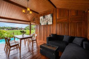 a living room with a couch and a table at De Sirame Villa in Ubud