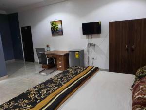 a hotel room with a desk and a bed and a deskictericter at EdJames Lodge in Ashaiman
