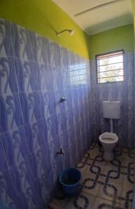 a bathroom with a toilet in the corner of a room at The Apple Bite in Malindi