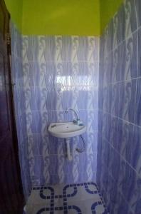 a bathroom with a sink on a tiled wall at The Apple Bite in Malindi