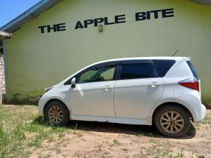 a white car parked in front of a building at The Apple Bite in Malindi