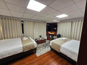 a hotel room with two beds and a couch at Casa Hotel Lago Titicaca in Puno
