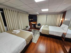 a hotel room with two beds and a couch at Casa Hotel Lago Titicaca in Puno