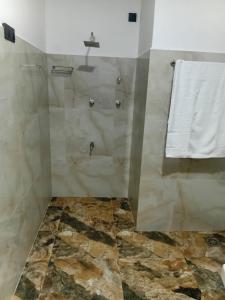 a bathroom with a shower with a stone floor at 7C Villa in Galle