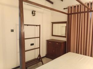 a bedroom with a bed and a mirror and a dresser at 7C Villa in Galle