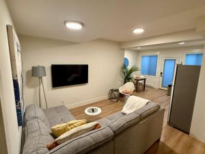 ein Wohnzimmer mit Sofa und Flachbildfernseher in der Unterkunft WT Modern Nest in Kelowna
