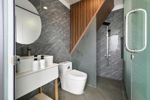 a bathroom with a toilet and a sink and a mirror at M Home Riverside in Ho Chi Minh City