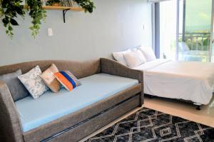 a couch with pillows and a bed in a room at Condo Inspiria Beside Abreeza Mall in Davao City +24 photos