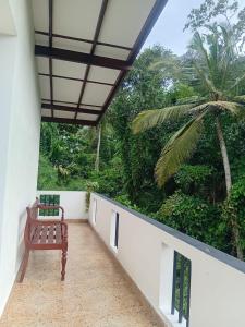 a bench sitting on a balcony with a palm tree at 7C Villa in Galle