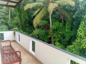 a bench sitting on a balcony with a palm tree at 7C Villa in Galle +12 photos