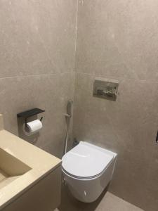 a bathroom with a white toilet and a sink at استديو in Al Khobar +10 photos