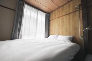 a bedroom with a white bed with a window at Sand Village Kikuna in Kikuna +73 photos