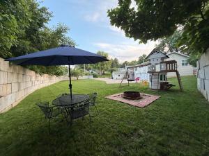a table with an umbrella in a yard with a playground at House in Hannibal in Hannibal