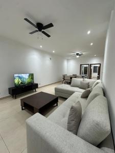 a living room with two couches and a ceiling fan at Cumbres Living in Saltillo