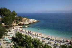 a beach with chairs and people in the water at Ria's Garden House in Kassiopi