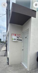 a sign on the side of a building with a door at Departamentos De Cadereyta in Cadereyta Jiménez +1 photo