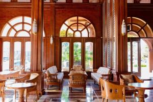 a lobby with tables and chairs and windows at Le' VIVA Resort Mui Ne in Mui Ne +54 photos