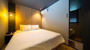 a bedroom with a large white bed and a mirror at Hotel Deluxe in Tumo