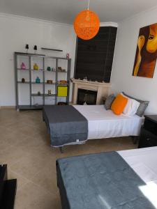 a bedroom with two beds and a fireplace at Santa Rita Guest House in Olhão
