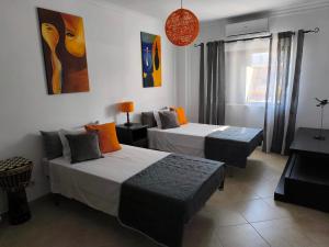 a hotel room with two beds and a couch at Santa Rita Guest House in Olhão
