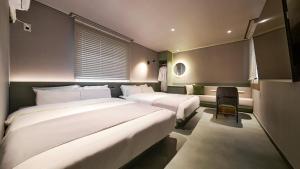a hotel room with two beds and a chair at Anook Hotel Busan Gwangalli in Busan +154 photos