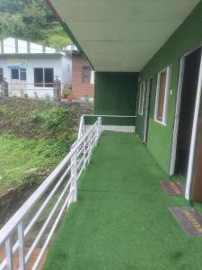 a hallway of a green building with a white fence at Inaya resort in Phata