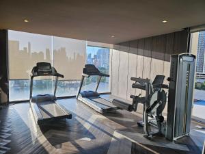 a gym with three tread machines in a building at Urbitia Thonglor in Klong Toi