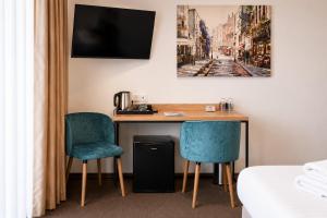 ein Hotelzimmer mit Schreibtisch und zwei Stühlen in der Unterkunft Hotel Opole Centrum in Oppeln