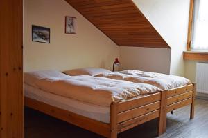 a bedroom with a large bed with a wooden roof at Ferienwohnung Wiedenhofer in Regenstauf +2 photos